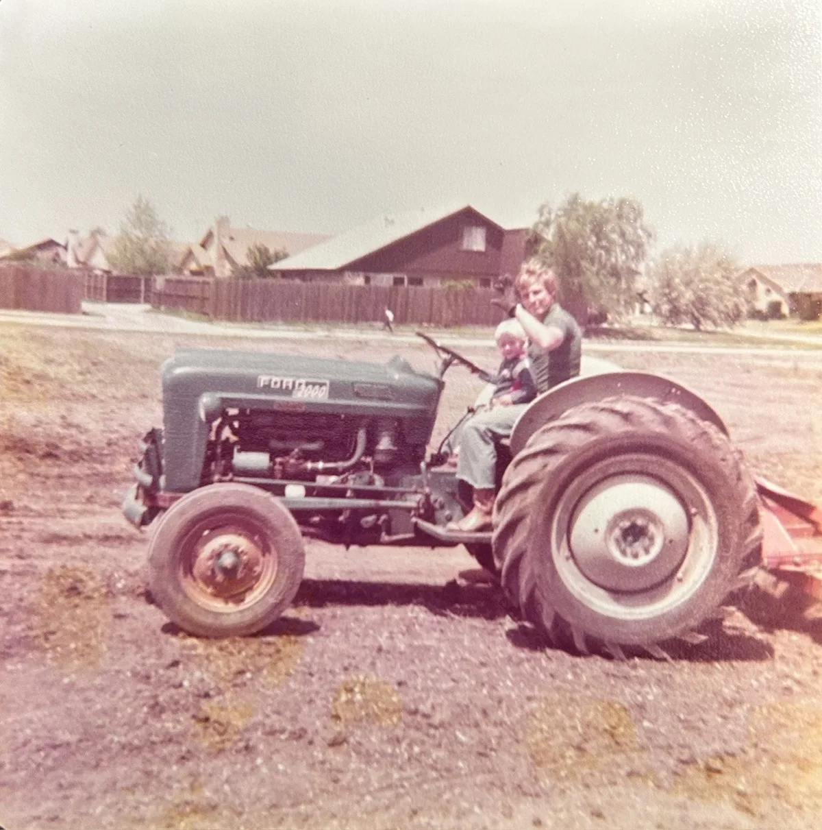 Dr. Homer Adams with his son, Dr. Homer Adams II, on a tractor in 1978 at the current site of Adams Chiropractic Health Center in Plano, TX